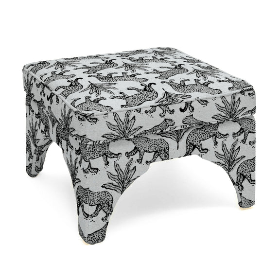 Upholstered ottoman in white with black jungle animal print, padded top, short turned legs