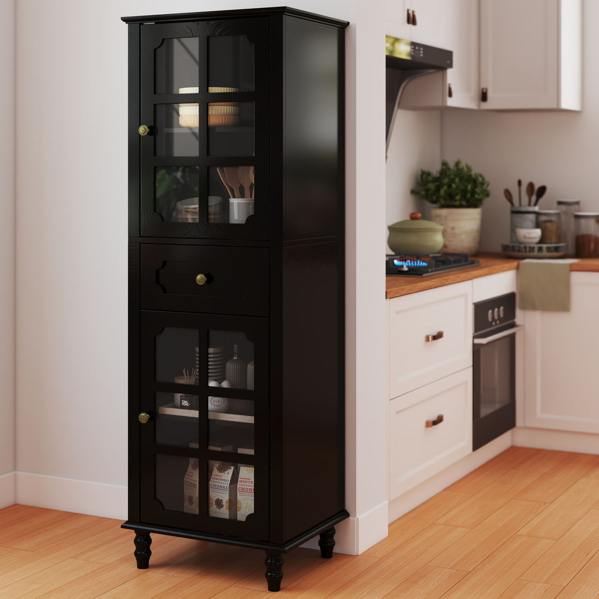 Black freestanding curio cabinet with glass grid doors and center drawer, shown stocked in a kitchen