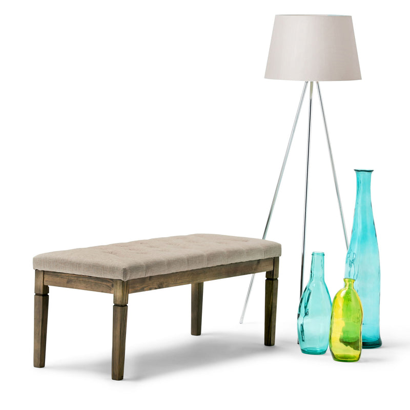 Upholstered tufted ottoman bench with light fabric seat and dark wood legs