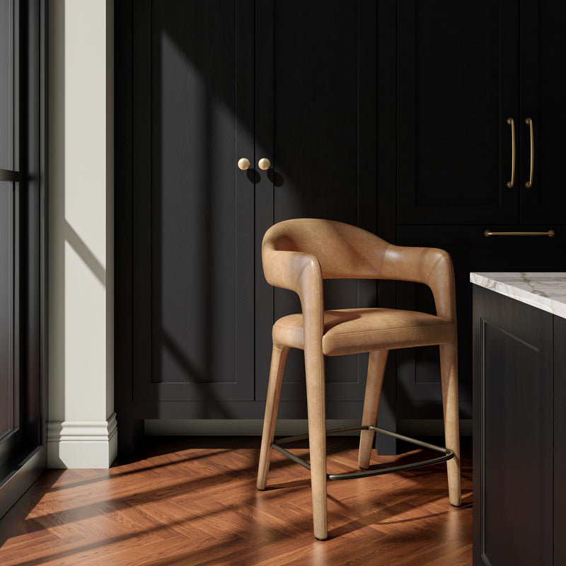 Brown counter stool with curved arms and upholstered seat, wood legs, and metal footrest.