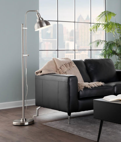 Gold metal floor lamp with arched stem and dome shade next to sofa