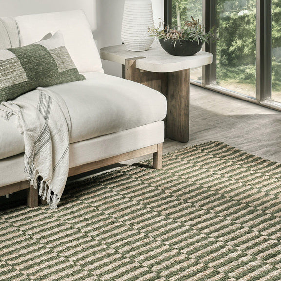 Green and natural jute rug with striped pattern in a living room setting