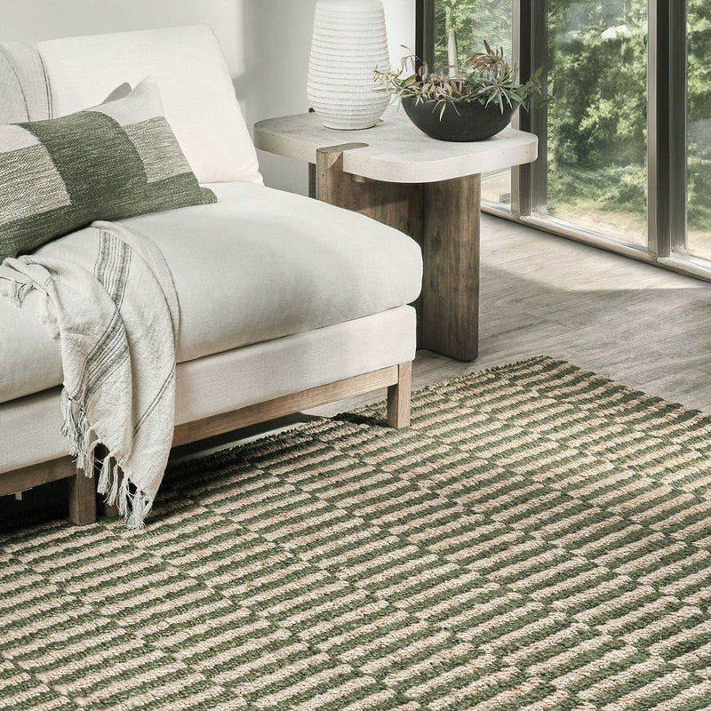 Green and natural jute rug with striped pattern in a living room setting