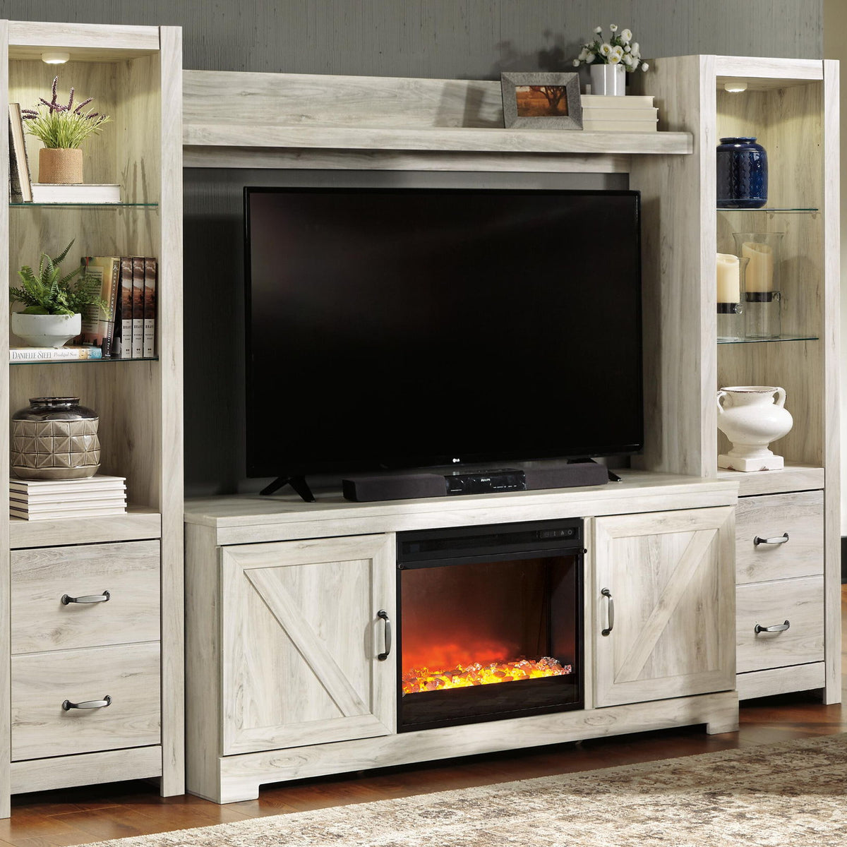 Light beige entertainment center with TV mount and lower electric fireplace insert
