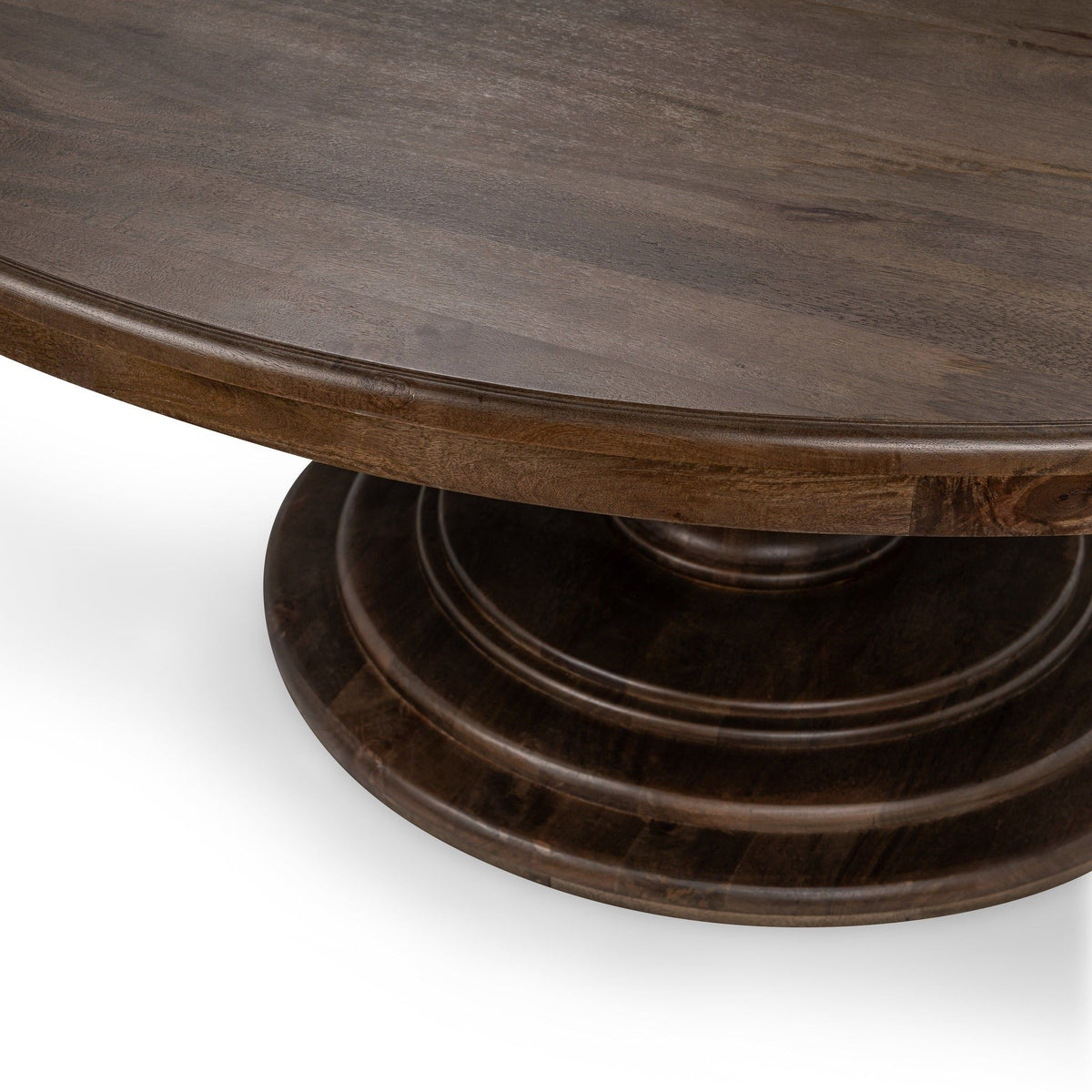 Dark brown round dining table with pedestal base and curved apron
