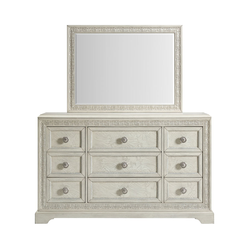 White dresser with mirror featuring three rows of drawers and round silver knobs.