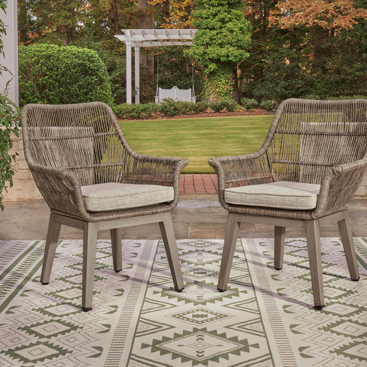 Set of 2 beige woven armchairs with light gray cushions, side-by-side arrangement