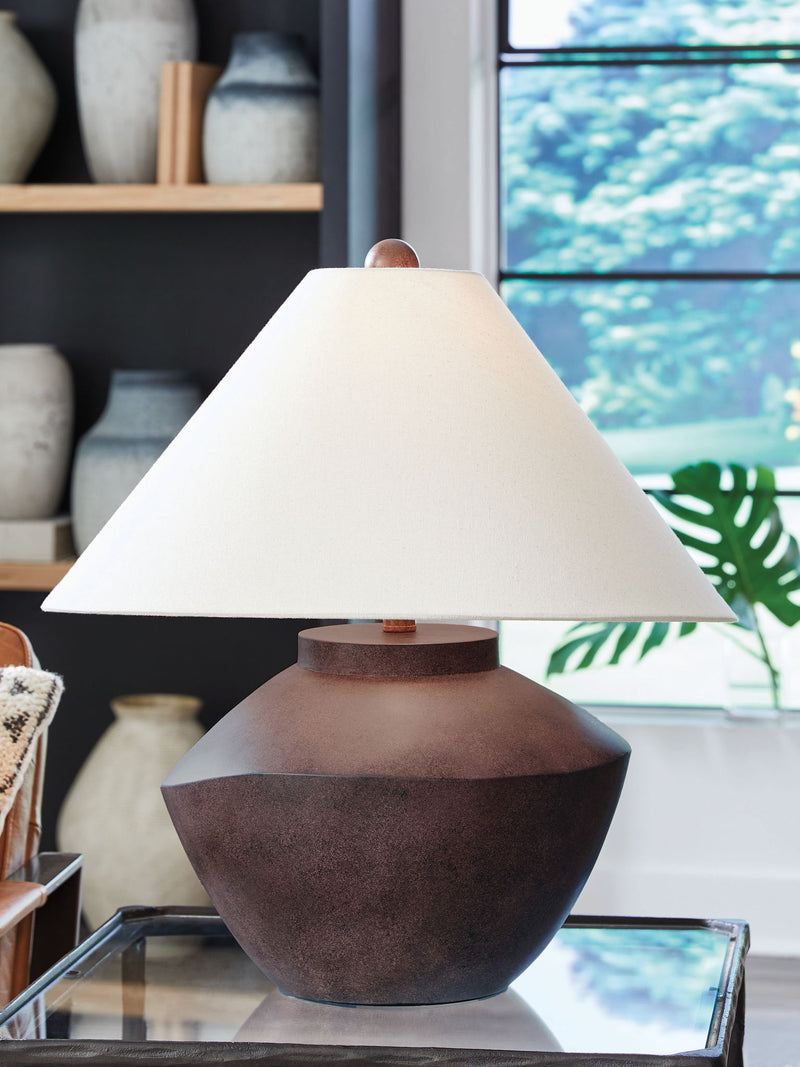 Antique brown poly table lamp on tabletop with off-white shade