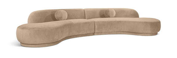 Beige velvet sectional sofa with tufted cushions and curved chaise profile