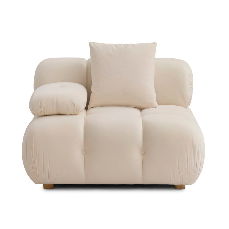 Cream corner chair with two pillows, padded armrests, and tufted seat sections