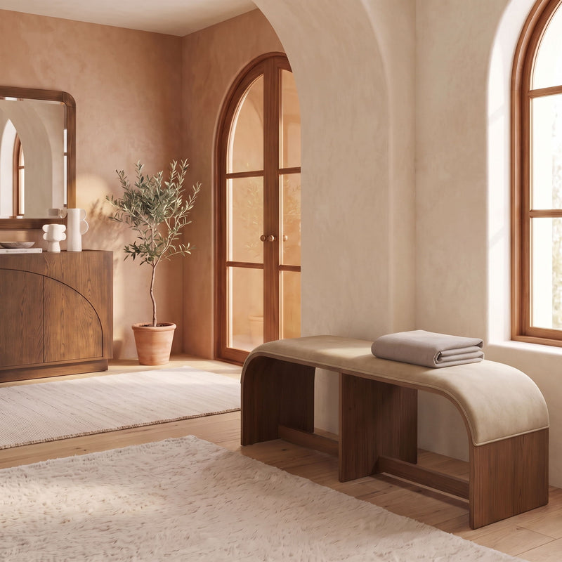 Beige velvet upholstered bench with dark wooden frame in a room setting