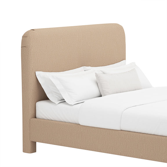 Upholstered bed with rounded headboard and low foot, light brown fabric, white bedding