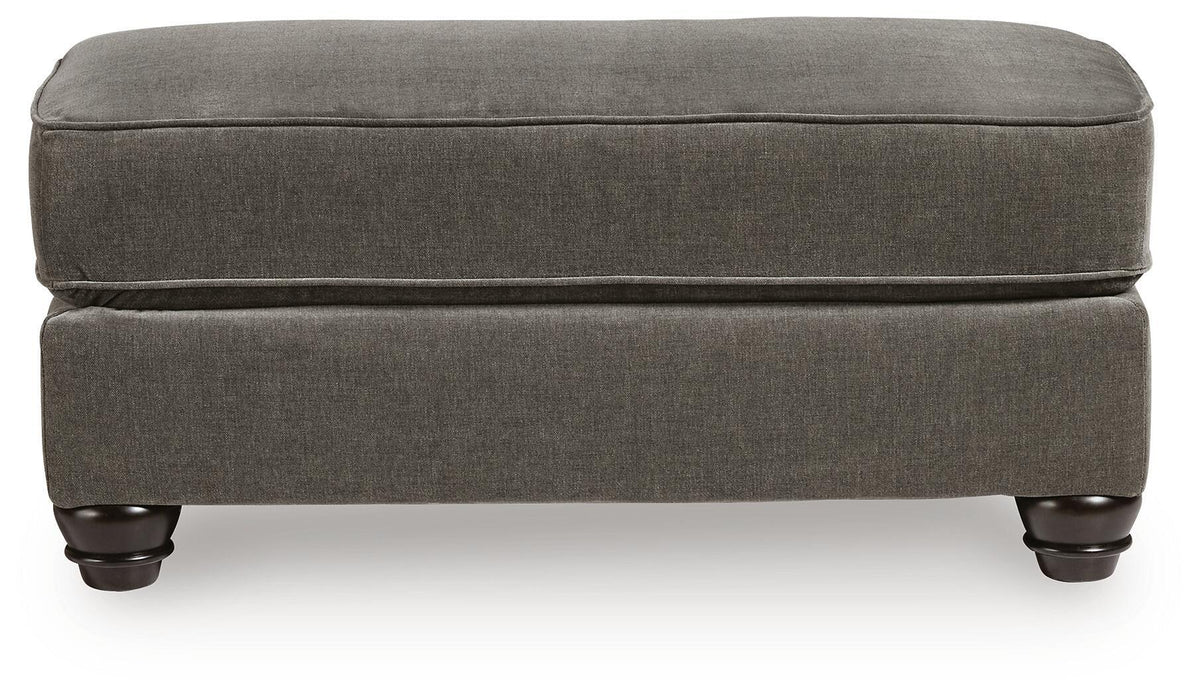Dark gray fabric ottoman with low profile base and turned legs