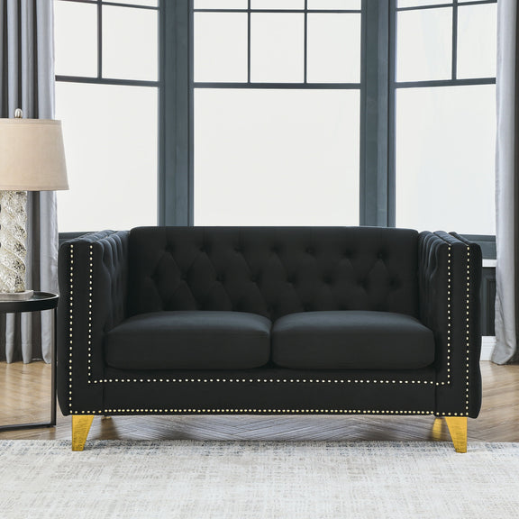 Black button-tufted sofa with nailhead trim, two-seat back, and gold legs