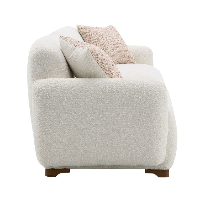 Beige boucle sofa with two patterned toss pillows, front view