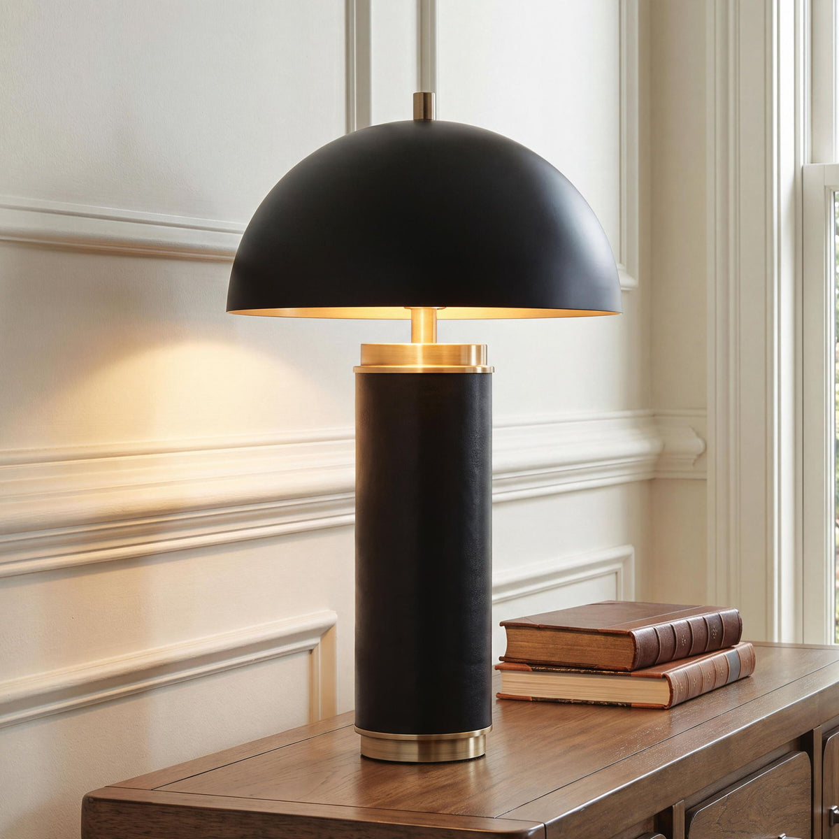 Black metal table lamp with dome shade, gold stand, warm light glow