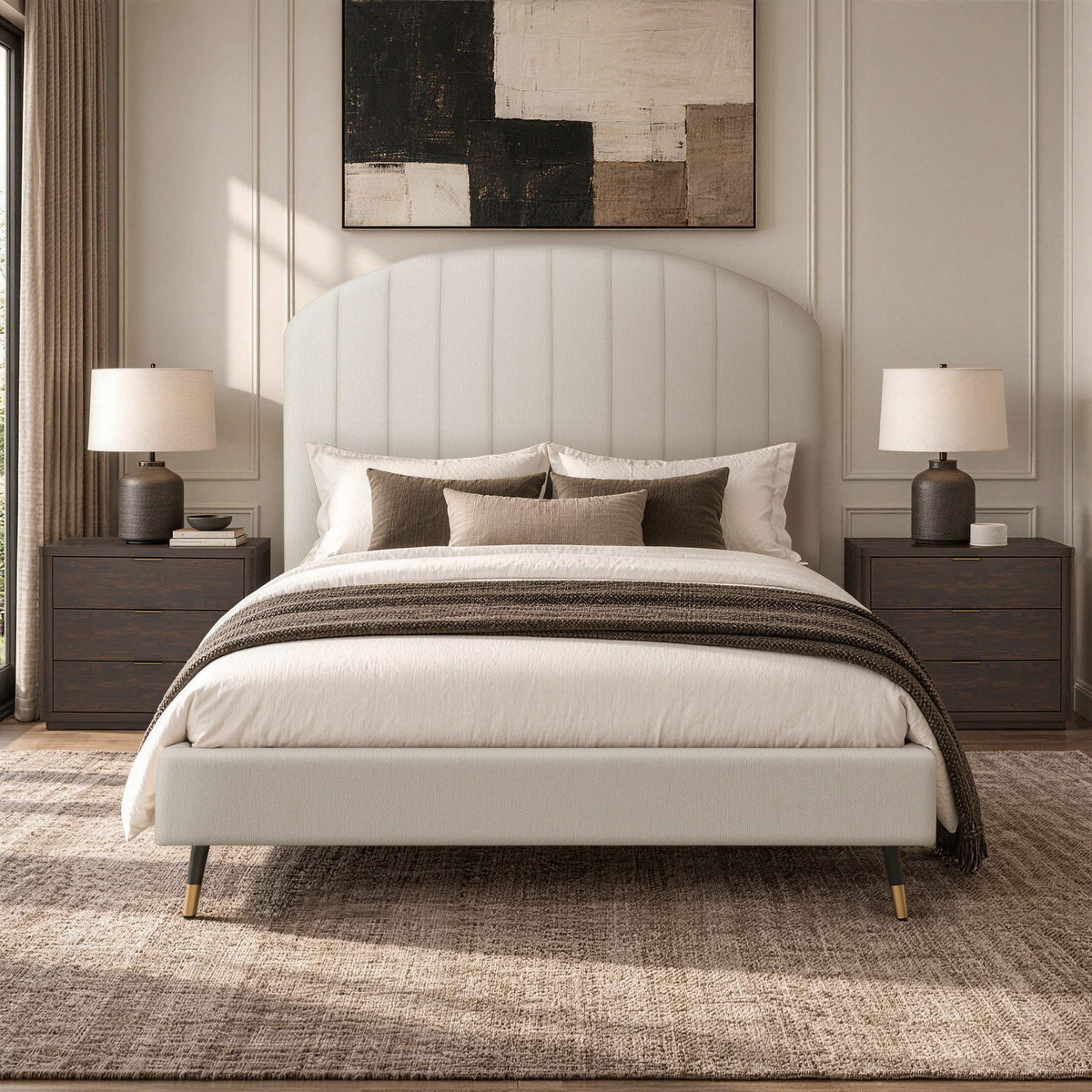 Beige arched upholstered bed with white duvet and brown throw blanket