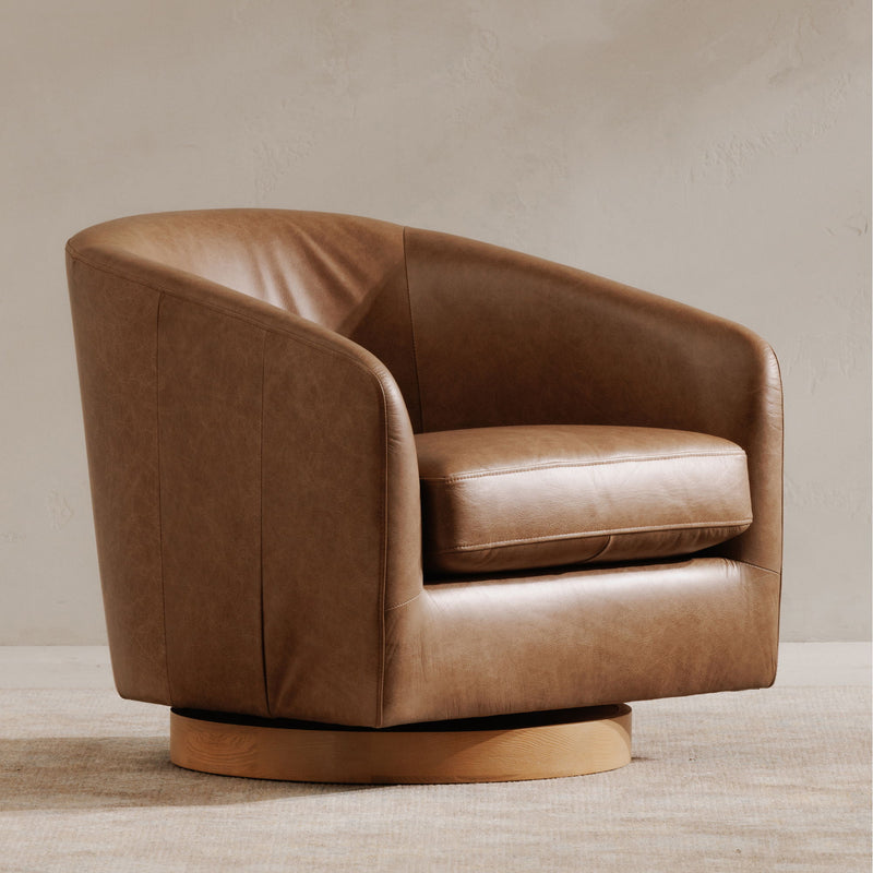 Tan swivel accent chair with rounded arms, tufted seat, and low back support.