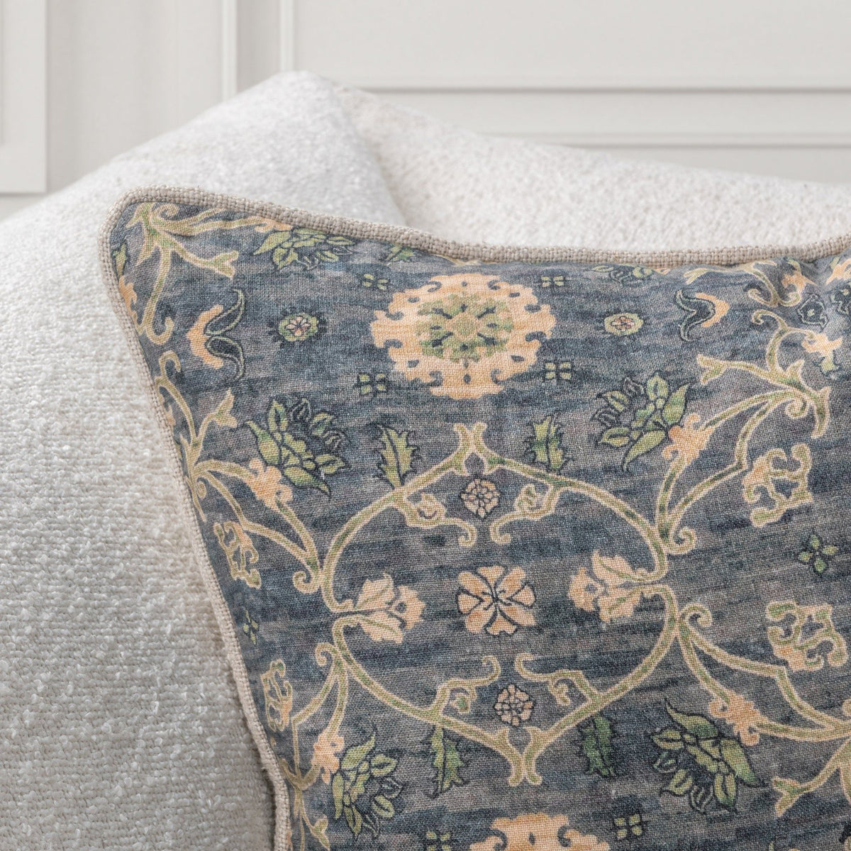 Close-up of blue-gray accent pillow fabric with cream and tan vine damask pattern
