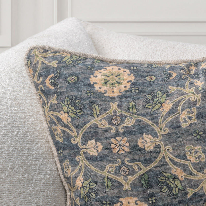 Close-up of blue-gray accent pillow fabric with cream and tan vine damask pattern