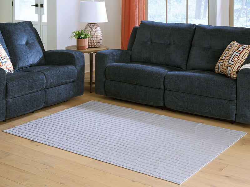 Light gray washable rug spread flat with wavy stripe pattern and bound edge