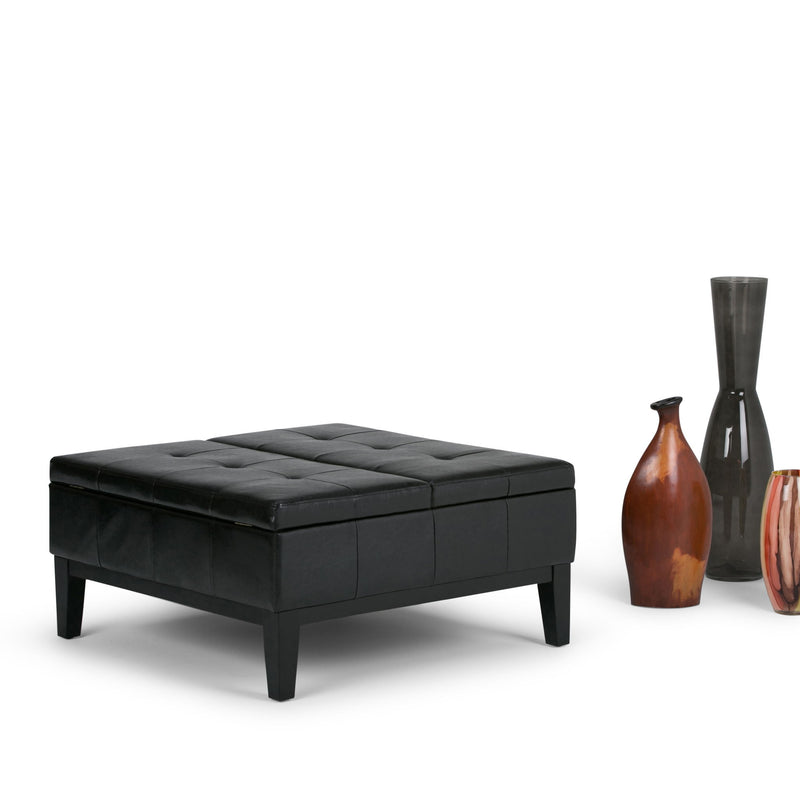 Black cushioned storage ottoman with tufted lid and dark wooden legs