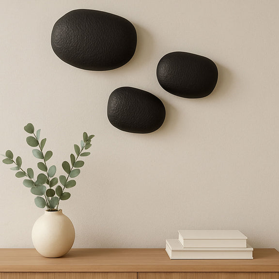 Three black textured oval cast-aluminum wall sculptures with matte finish