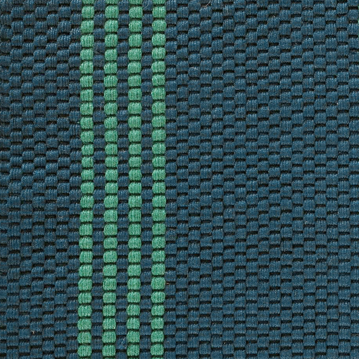 Close-up of deep blue woven rug texture with green vertical stripe detail.