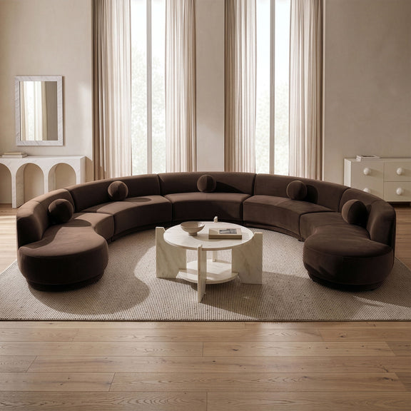Brown velvet sectional sofa with rounded seats and curved back cushions in a room.