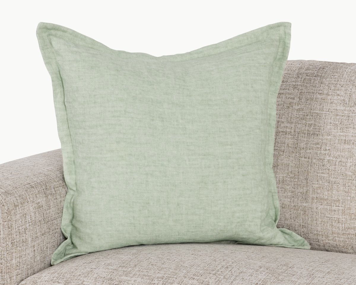 Mint square pillow on sofa with woven linen texture and stitched border