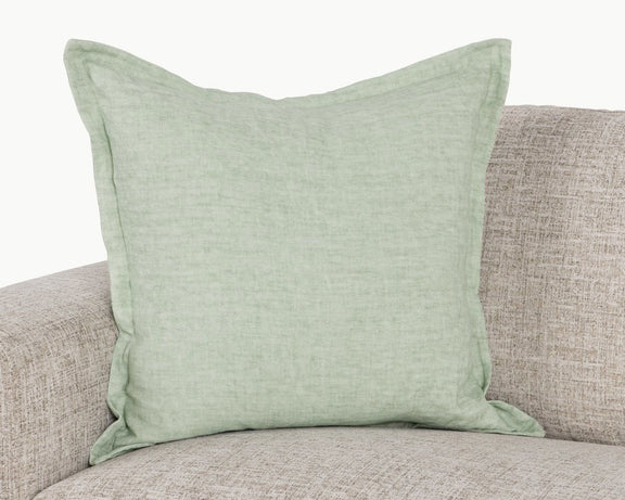 Mint square pillow on sofa with woven linen texture and stitched border