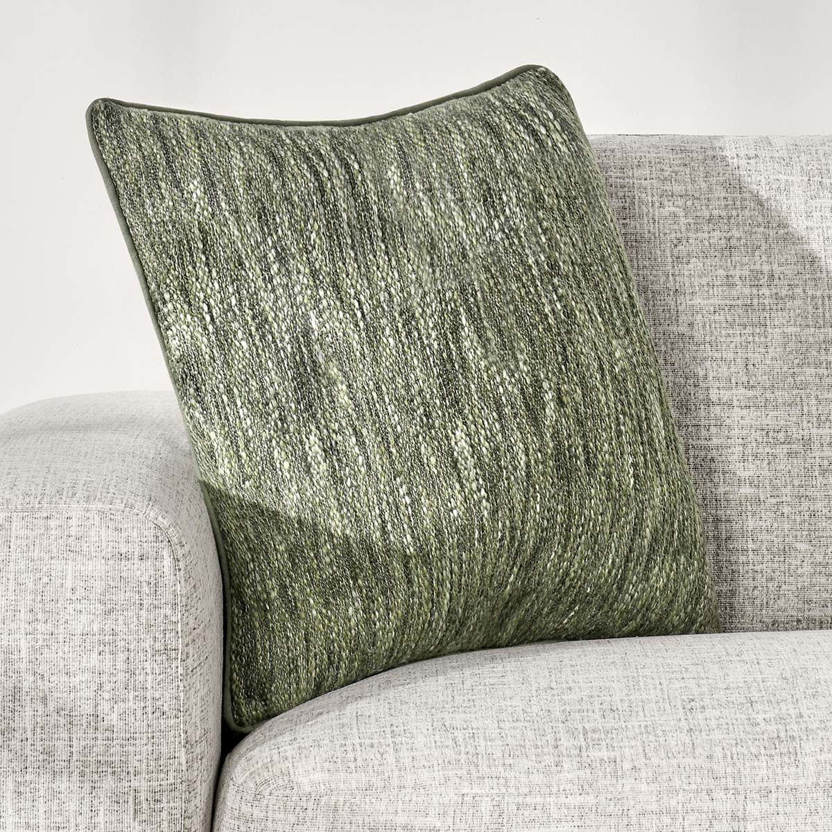 Cedar green linen-look square throw pillow angled on furniture, showing textured front