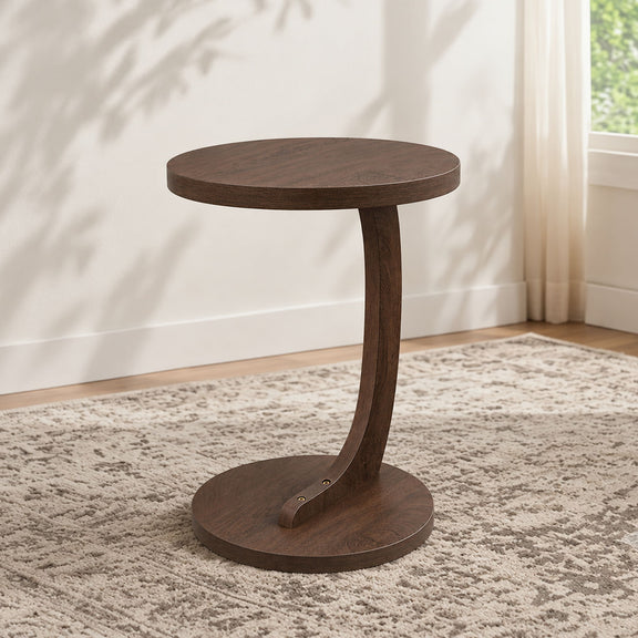 Dark brown round end table with pedestal base and lower shelf on carpet
