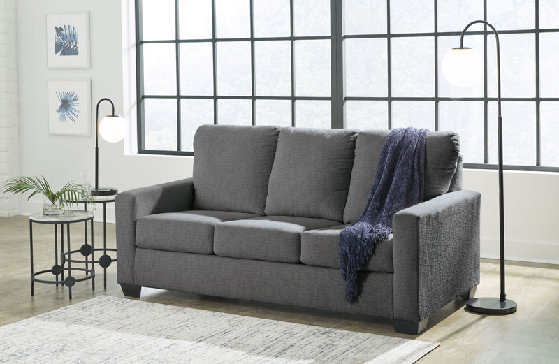 Dark gray 3-seat sofa with square arms, tufted cushions, and a blue throw blanket draped