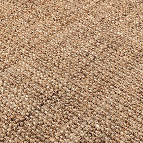 Close-up of woven jute rug texture in light beige and tan threads