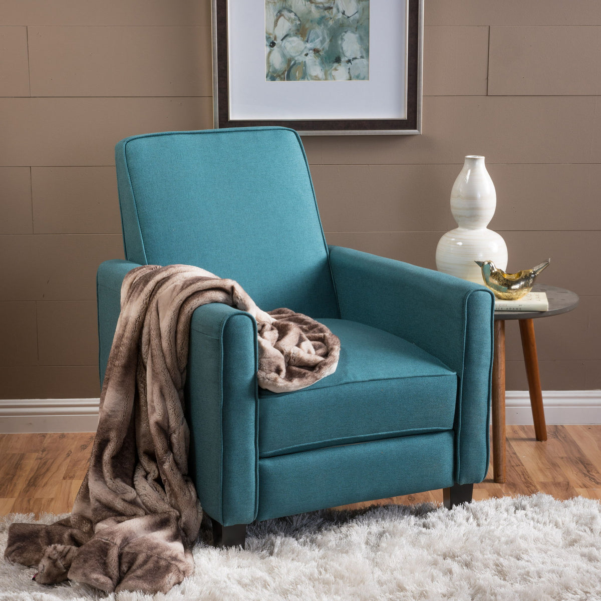 Teal upholstered push-back recliner chair with throw blanket on the seat