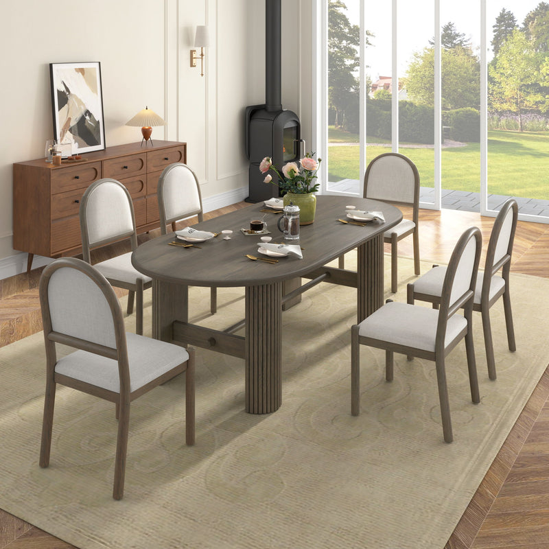 Dark brown oval dining table with six upholstered chairs, side view, fabric seats