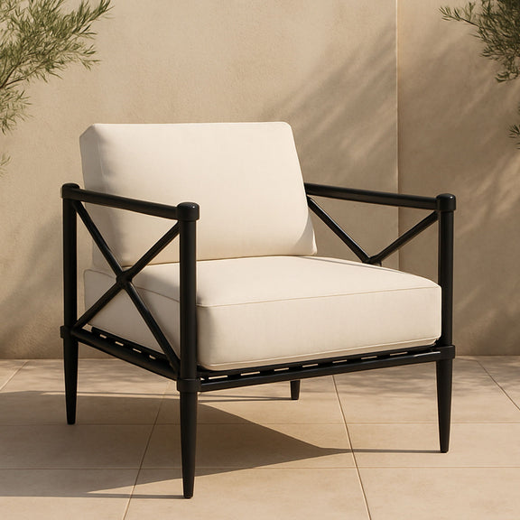 Cream outdoor accent chair with black X-brace metal frame and thick seat cushion