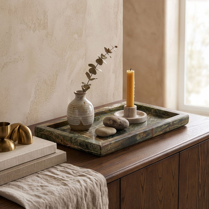 Brown-toned marble tray with candle and small stone decor on table