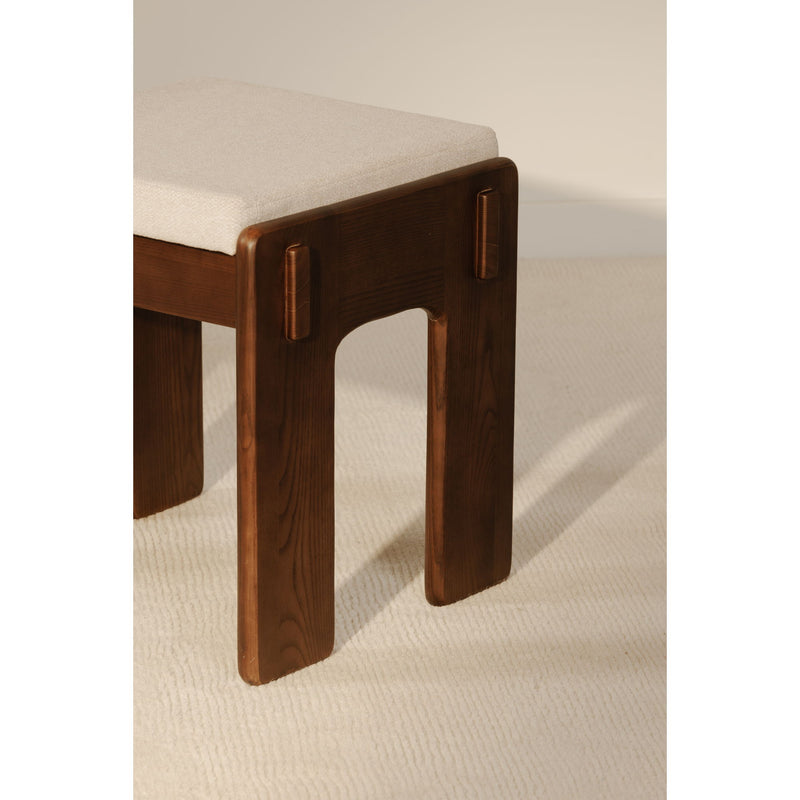 Backless counter stool with dark brown wood legs and light beige upholstered seat