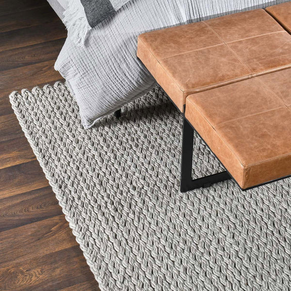 Gray wool area rug with dense woven surface and short fringed border