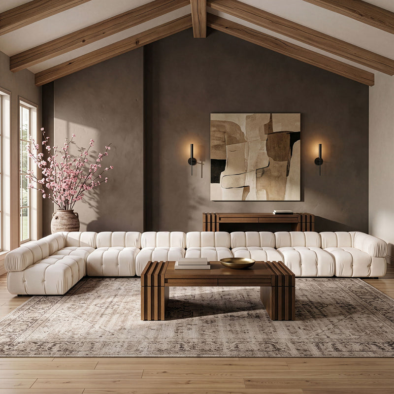 White velvet L-shaped sectional sofa with tufted back cushions and rounded arms.