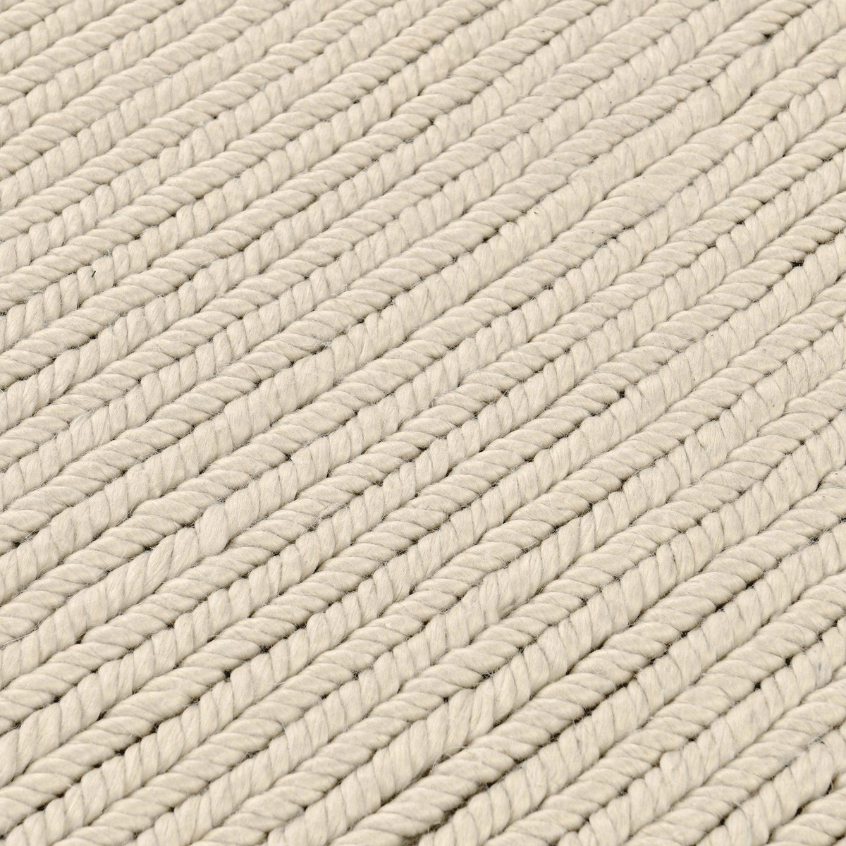 Dawson rug close-up in off-white with diagonal braided yarn rows and soft gray accents