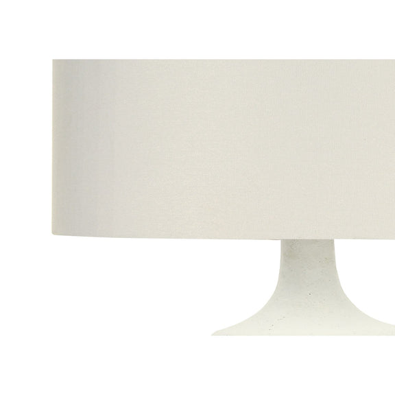 Cream resin table lamp close-up with fabric drum shade and curved base
