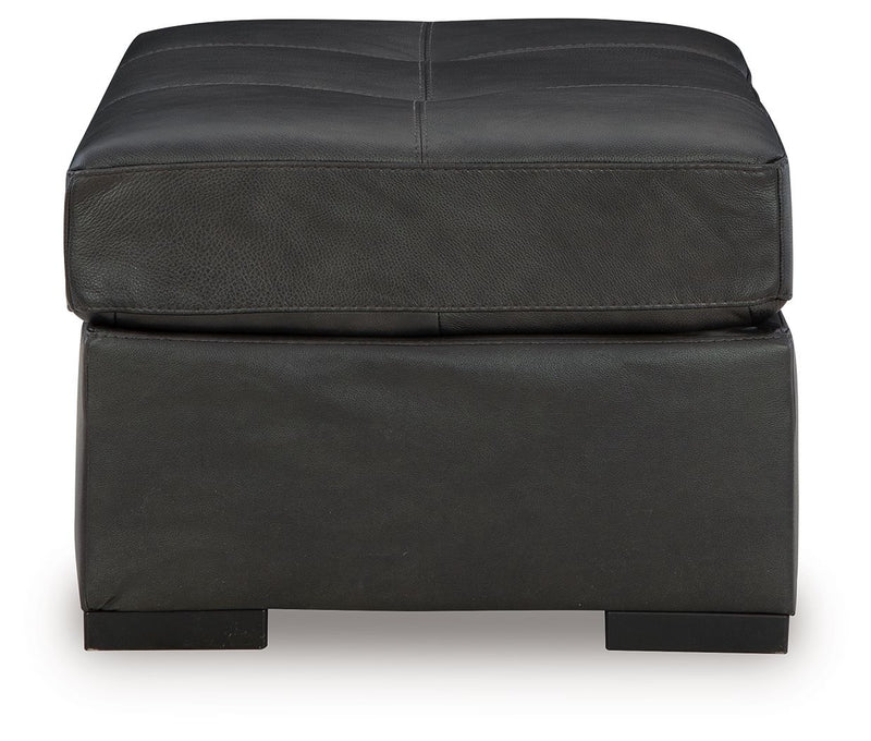 Oversized accent ottoman in dark gray with stitched panels and upholstered sides