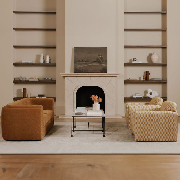Dark brown framed landscape painting above a white fireplace in living room