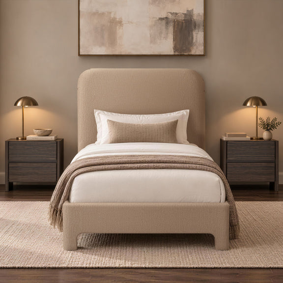 Beige upholstered bed with rounded headboard, white bedding, and draped throw blanket