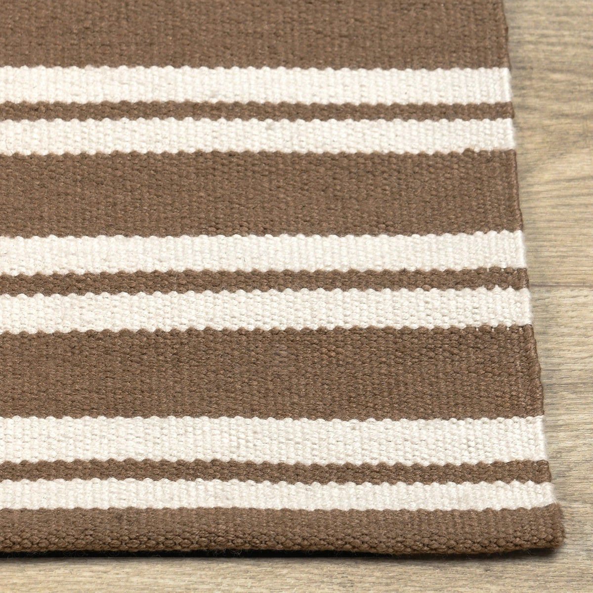 Striped rug border close-up with brown and cream horizontal bands