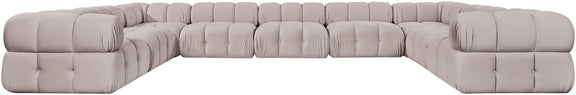 Light gray velvet sectional with tufted cushions and curved corner arms