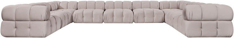 Light gray velvet sectional with tufted cushions and curved corner arms